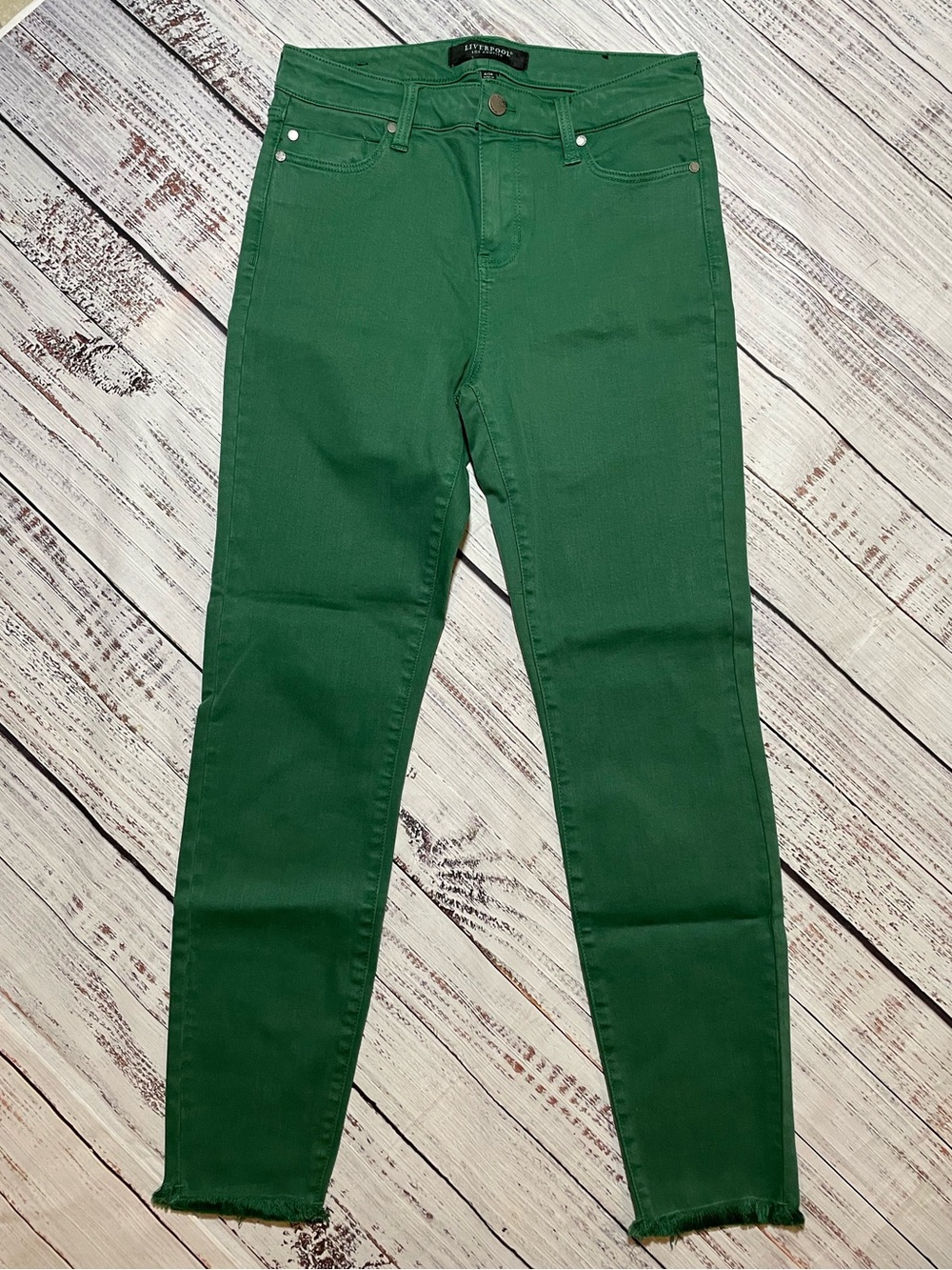 Liverpool skinny jeans featuring a frayed, raw hem at the ankles. Green. Size 6